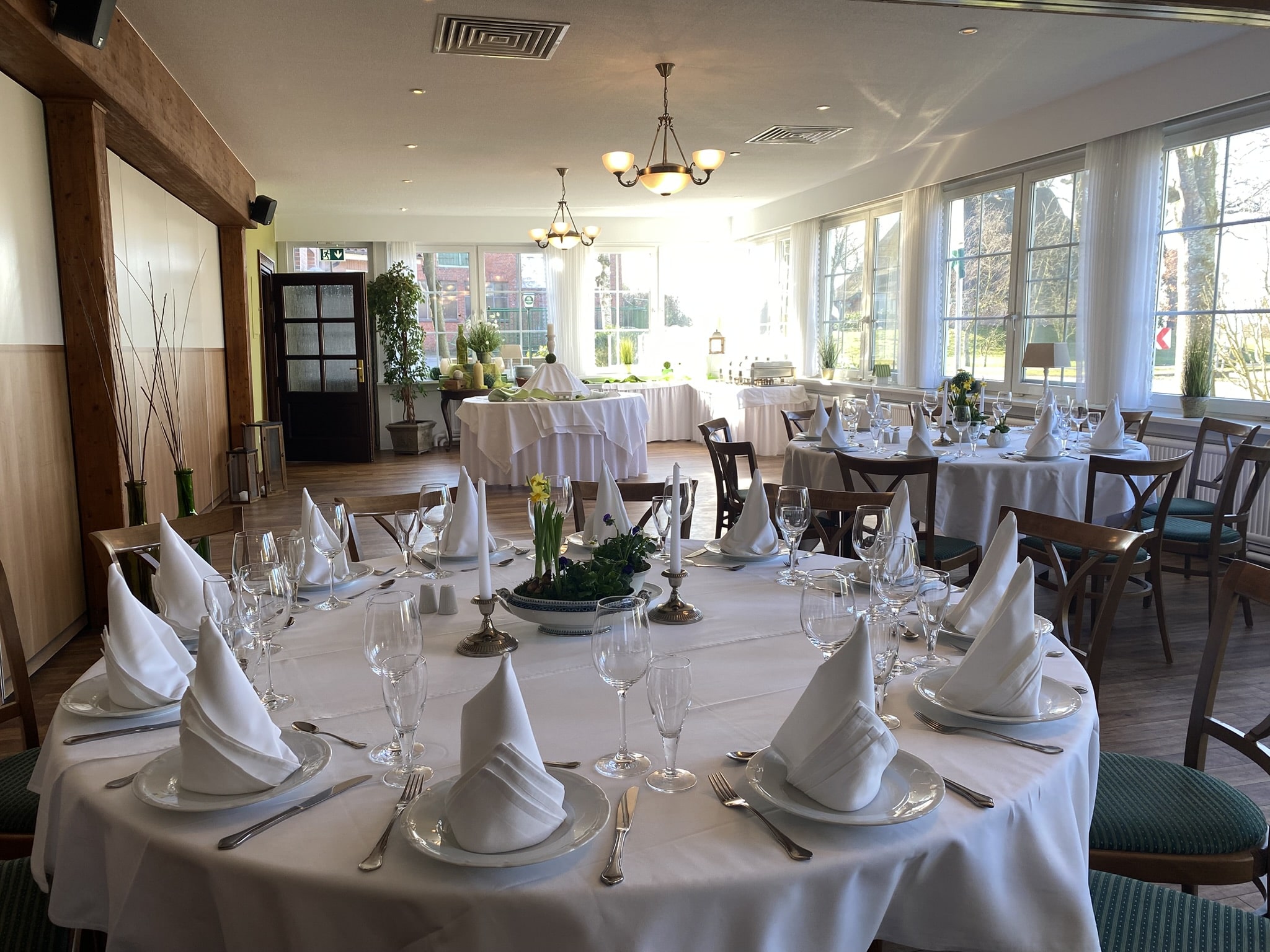 Veranstaltungsaal mit festlich gedeckten Tischen.